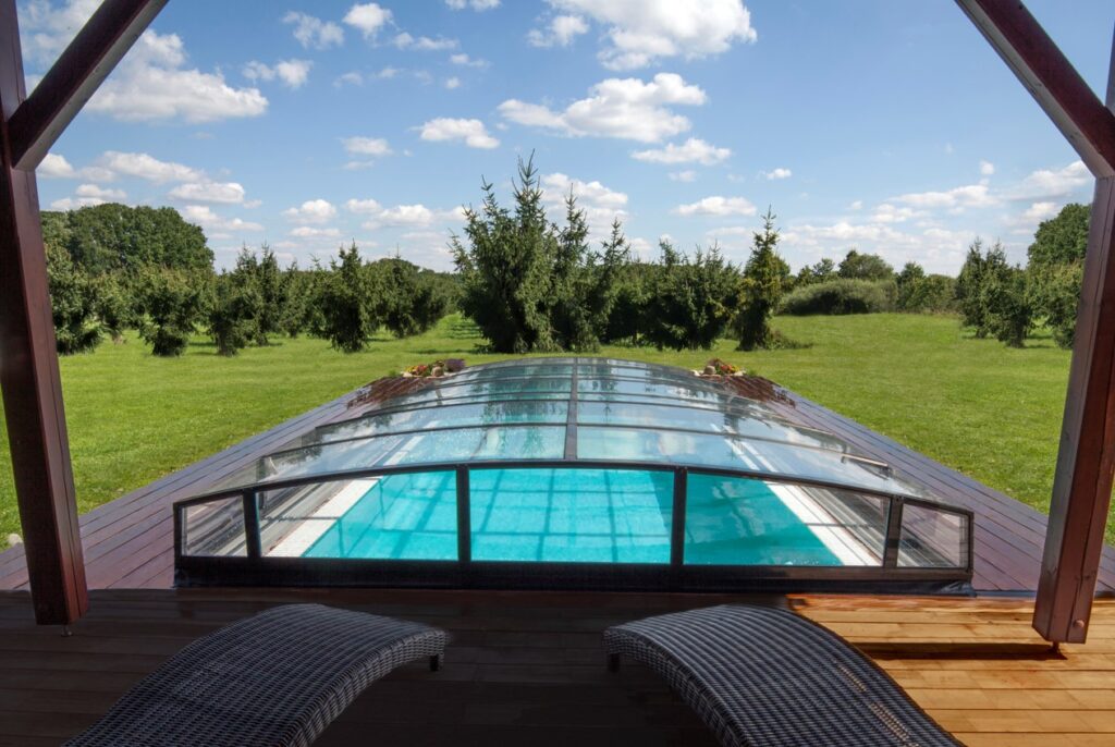 Outdoor pool enclosure over pool on large deck.